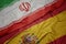 waving colorful flag of spain and national flag of iran