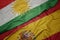 waving colorful flag of spain and national flag of kurdistan