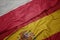 waving colorful flag of spain and national flag of poland