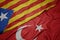 waving colorful flag of turkey and national flag of catalonia