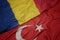 waving colorful flag of turkey and national flag of romania