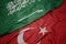 waving colorful flag of turkey and national flag of saudi arabia