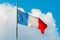 Waving colorful France flag on blue sky.