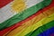 waving colorful gay rainbow flag and national flag of kurdistan