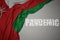 waving colorful national flag of oman on a gray background with broken text pandemic. concept