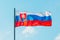 Waving colorful Slovakia flag on blue sky.