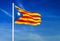 Waving flag of Catalonia on the blue sky background