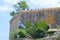 Waving flag of Greece in front of medieval fortress wall against