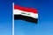 Waving flag of Iraq on the blue sky background