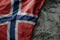 waving flag of norway on the old khaki texture background. military concept