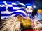 Waving greek flag against sunset sky with colorful exploding fireworks. Celebration day concept. Greece flag with salute