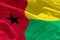 Waving Guinea-Bissau flag for using as texture or background, the flag is fluttering on the wind
