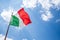 Waving Italian flag against blue sky.