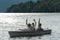 Waving men sitting in motorboat back lit