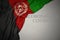 waving national flag of afghanistan on a gray background with text coronavirus covid-19 . concept