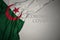 waving national flag of algeria on a gray background with text coronavirus covid-19 . concept