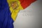 waving national flag of andorra on a gray background with text coronavirus covid-19 . concept