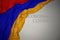 waving national flag of armenia on a gray background with text coronavirus covid-19 . concept
