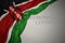 waving national flag of kenya on a gray background with text coronavirus covid-19 . concept