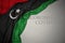 waving national flag of libya on a gray background with text coronavirus covid-19 . concept