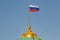 Waving national flag of Russian Federation on the dome of Grand Kremlin Palace against blue sky in sunny morning