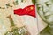 Waving red national flag of China against one chinese yuan banknote background. Finance concept