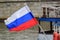 Waving russian flag on the flagpole at the stern of a pleasure boat closeup on a background of Moskva river