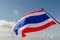 Waving Thai flag of Thailand with blue sky background.