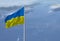 Waving Ukraine flag against a blue sky with clouds and empty space for text