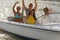 Waving young people sitting in motorboat