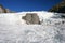 Wavy flat ice in front of jagged glacier ice on mountain