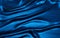 Wavy folds of grunge silk texture blue satin velvet material