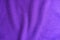 Wavy folds on violet knitted fabric