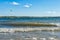 Wavy lake with a lonely kiteboarder flying over the water