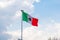 Wavy Mexican flag with a cloudy sky as background