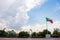 Wavy Mexican flag in public square with a cloudy sky as background