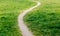 Wavy path trodden by people across the meadow.