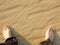 Wavy yellow sand texture background and male feet