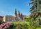 Wawel Cathedral: mixture of architecture styles in one church with pink flowers in a frontline and blue sunny sky in background