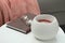 Wax air freshener, book and glasses on white table indoors. Interior element