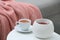 Wax air freshener and cup of hot tea on white table indoors. Interior element