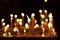 Wax candles fire flame in dark space inside church praying time religious atmospheric concept