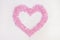 Wax for depilation of pink color. in the form of a heart. On white background. The concept of waxing,