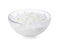 Wax flakes in glass bowl on white background. Homemade candle material