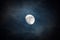 Waxing moon encircled by clouds