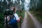 Way of Saint James pilgrim backpacker female going by the path through Eucalyptus forest  back view image shoot