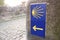 Way of St. James sign and unfocused pilgrims at background. Yellow scallop sign pilgrimage to Santiago de Compostela