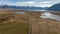 The way to Lake Ohau and the southern alps through alpine grasses and tundra terrain