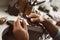 On the way to perfection. Close-up of male jeweler`s hands polishing silver ring at his jewelry making studio.