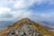 On the way to the summit trig point of a Scottish mountain Ben Vorlich with rocky path and dry grass under a majestic blue sky a